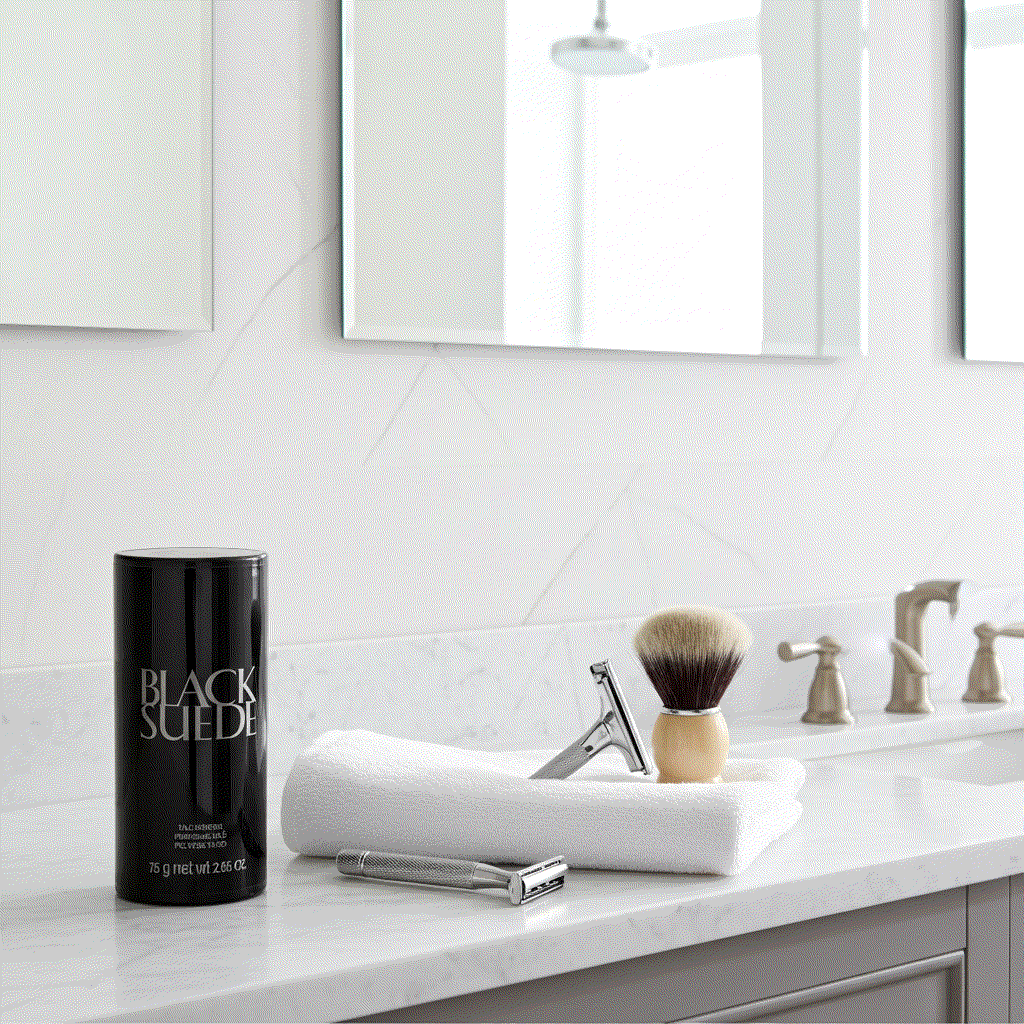 Black Suede talc powder 2.65 oz on bathroom counter with shaving brush and razor