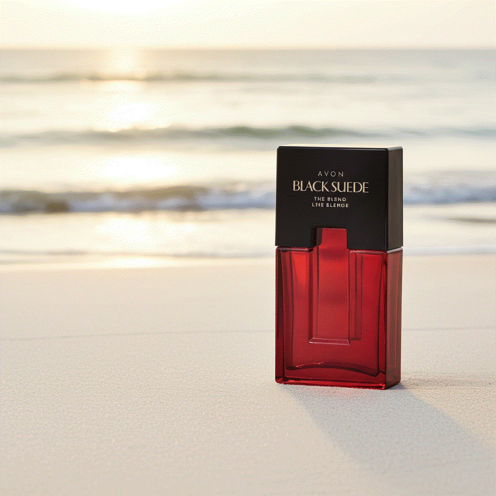 Avon Black Suede men’s eau de toilette bottle on sandy beach with ocean background